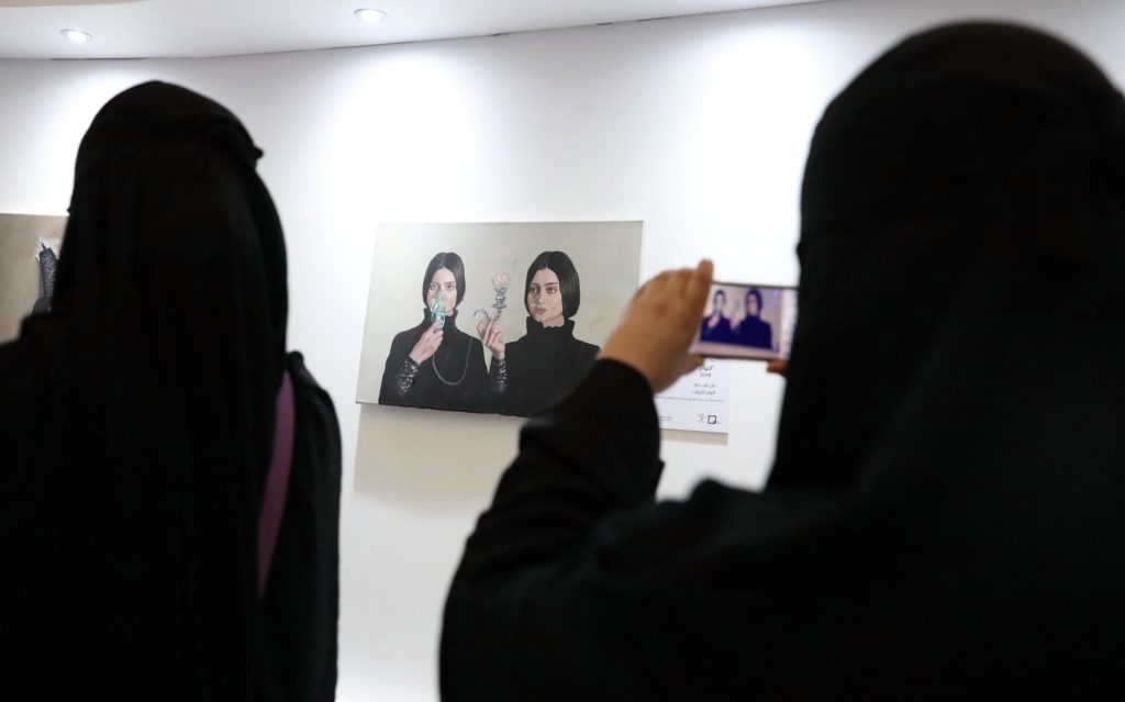 Donne saudite fotografano le opere dell'artista Sabah Al-Dhafiri durante un'esposizione a Riad, Arabia Saudita, 16 febbraio 2018. Epa/Amel Pain