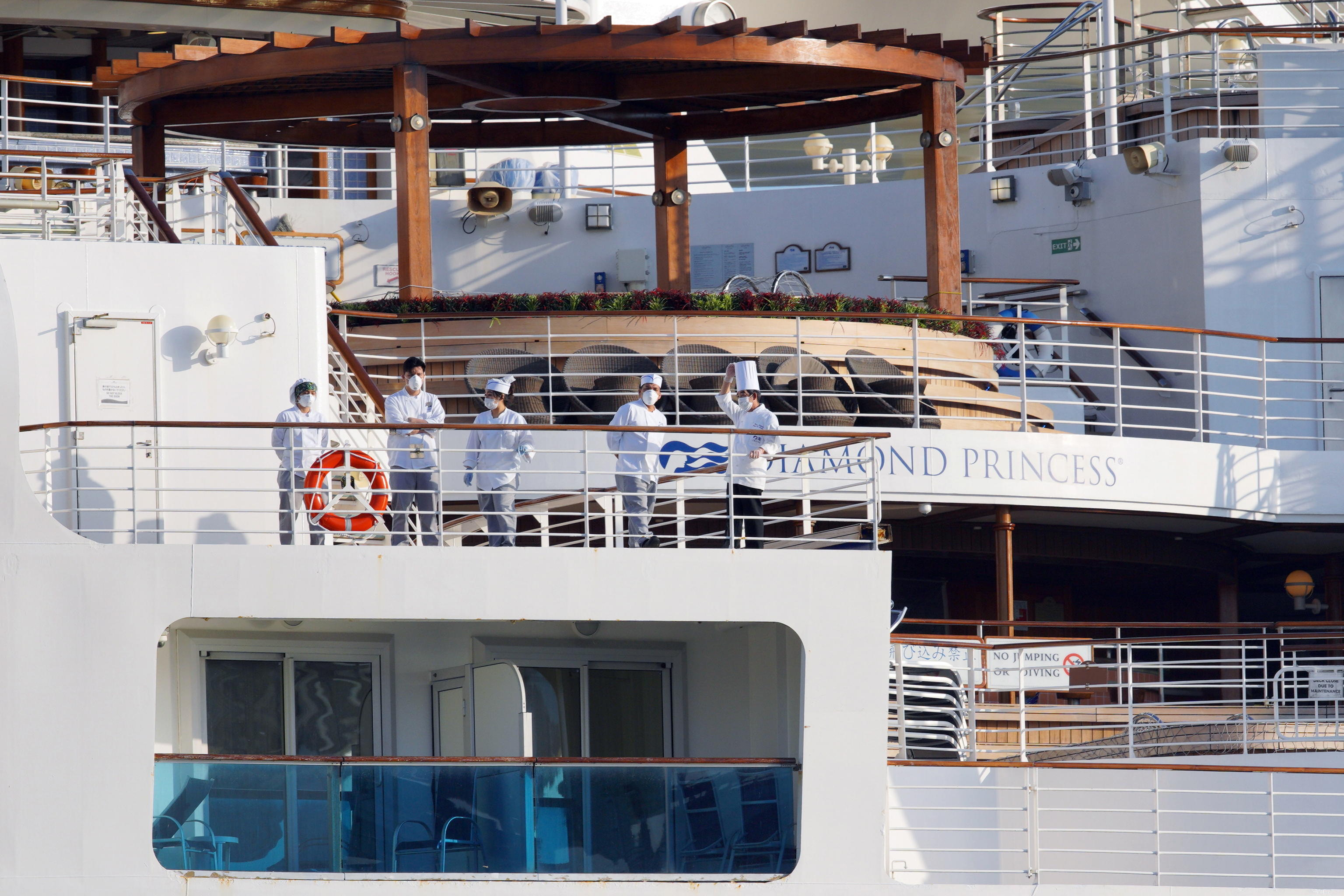 epa08234281 Crew members stand on a deck of the Diamond Princess cruise ship, which has been quarantined, at the Daikoku Pier Cruise Terminal in Yokohama, Japan, 21 February 2020. Since 19 February, passengers of the cruise ship have been disembarking, after a two-week-long quarantine period following the Covid-19 coronavirus outbreak.  EPA/JIJI PRESS JAPAN OUT EDITORIAL USE ONLY/  NO ARCHIVES