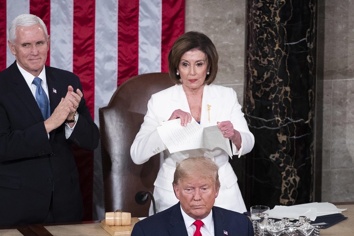 epa08193787 Speaker of the House Nancy Pelosi (C, top) tears up a copy of the State of the Union address that US President Donald J. Trump (C, bottom) just delivered, as US Vice President Mike Pence (L) looks on, in front of the floor of the US House of Representatives on Capitol Hill in Washington, DC, USA, 04 February 2020. President Trump delivers his address as his impeachment trial is coming to an end with a final vote on the two articles of impeachment scheduled for 05 February.  EPA/MICHAEL REYNOLDS