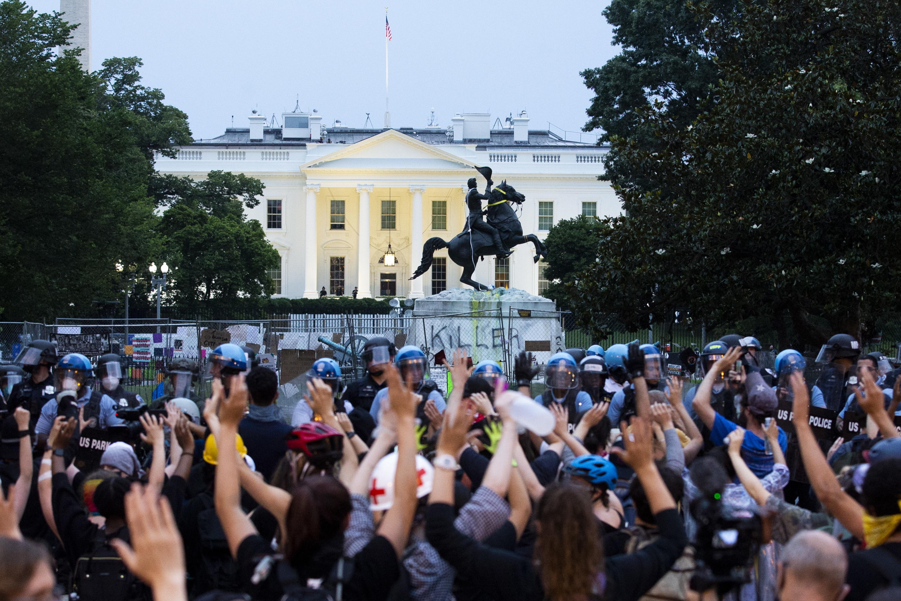 epa08503104 Protesters put their hands in the air as police clear out Lafayette Park across the street from the White House after protesters attempted to pull down the Andrew Jackson statue in the park, in Washington DC, USA, 22 June 2020. Police used chemical agents to clear out Lafayette Park and skirmishes broke out between protesters and police. The death of George Floyd in the Minneapolis police custody on 25 May 2020 has sparked global protests demanding justice and racial equality.  EPA/MICHAEL REYNOLDS
