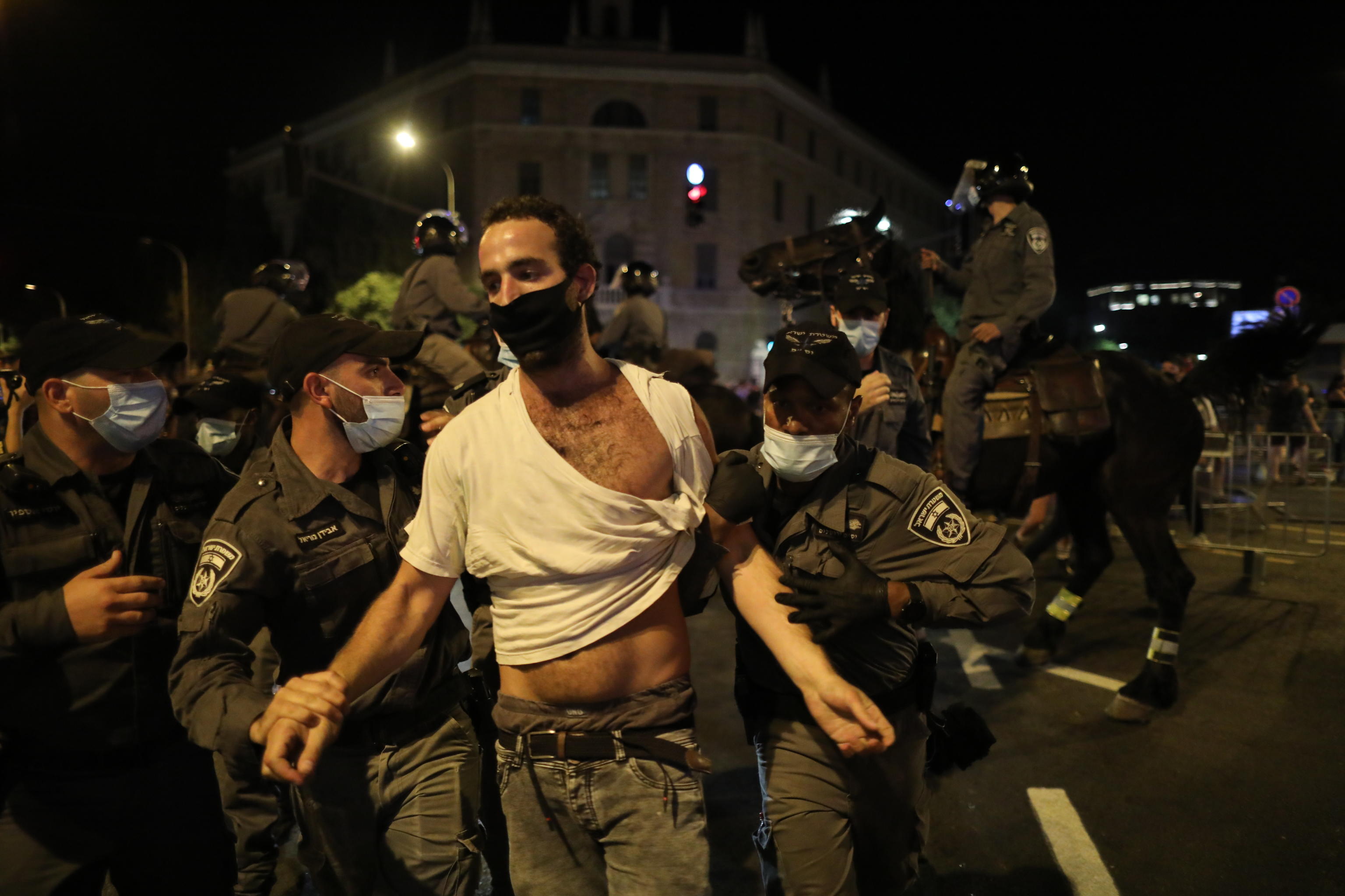 epa08546379 Israeli police arrest protesters during a rally against Israeli prime minister Benjamin Netanyahu in Jerusalem, Israel, 14 July 2020. Netanyahu faces an ongoing trial with indictments filed against him by the State Attorney's Office on charges of fraud, bribery and breach of trust.  EPA/ABIR SULTAN