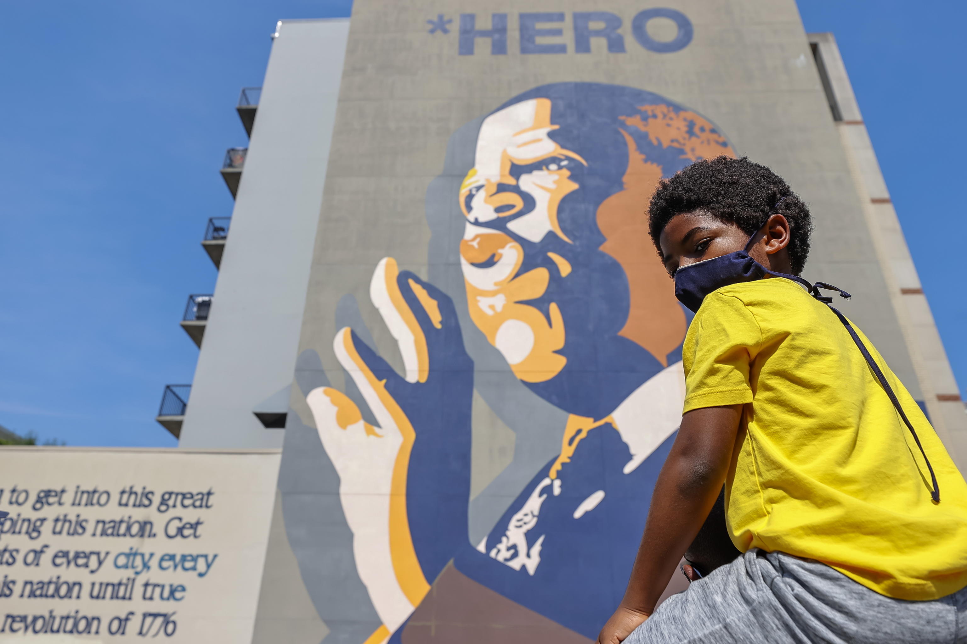 epa08553747 Blair Rankin, 6, sits on the shoulders of his father Matthew as people gather at a large mural of Civil Rghts leader and Democratic Representative from Georgia John Lewis along historic Auburn Avenue in Atlanta, Georgia, USA, 18 July 2020. Lewis died at age 80 on 17 July 2020 after being diagnosed with pancreatic cancer in December 2019. He was the youngest leader in the March on Washington of 1963.  EPA/ERIK S. LESSER