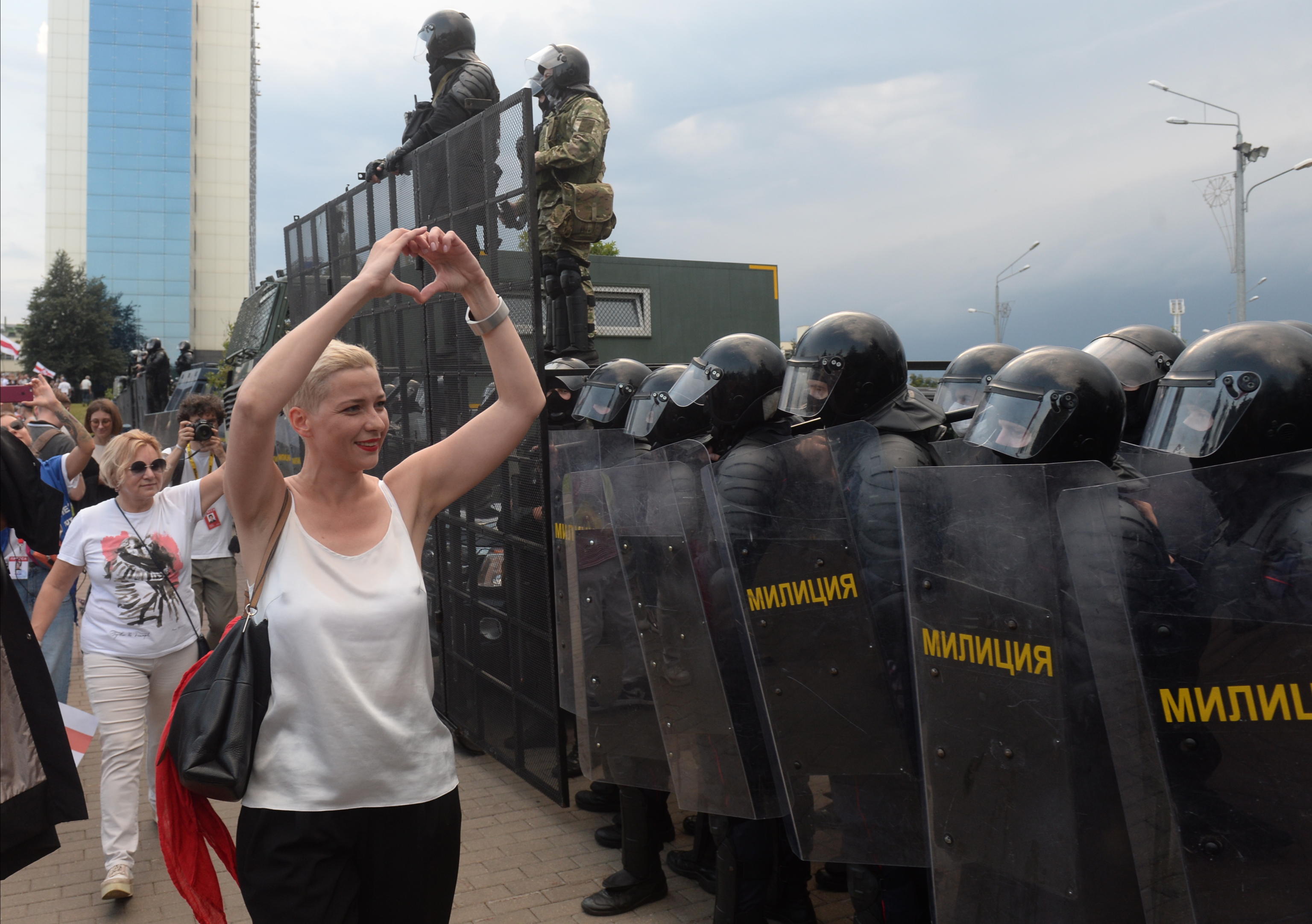 epa08635730 A woman shows a heart sign in front of police during a protest rally against the results of the presidential elections, in Minsk, Belarus, 30 August 2020. Opposition protests in Belarus continue against alleges poll-rigging and police violence at protests following election results claiming that president Lukashenko had won a landslide victory in the 09 August elections.  EPA/STRINGER