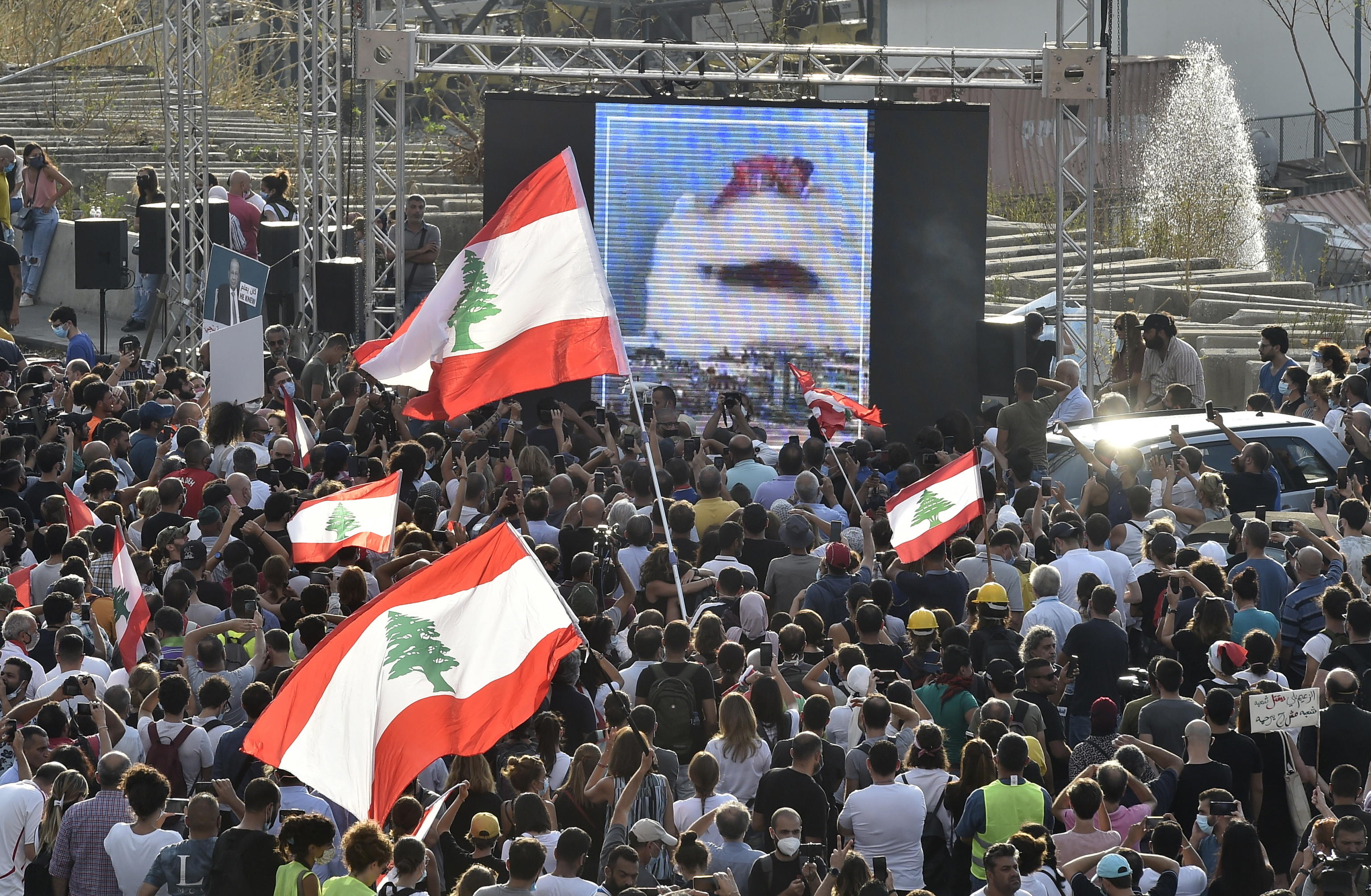 epa08597513 People gather near the devastated harbor area to commemorate the victims of the explosion that took place just one week earlier, in Beirut, Lebanon, 11 August 2020. The Lebanese Health Ministry said at least 160 people were killed, and more than 6,000 injured in the Beirut blast that devastated the port area on 04 August and believed to have been caused by an estimated 2,750 tons of ammonium nitrate stored in a warehouse.  EPA/WAEL HAMZEH