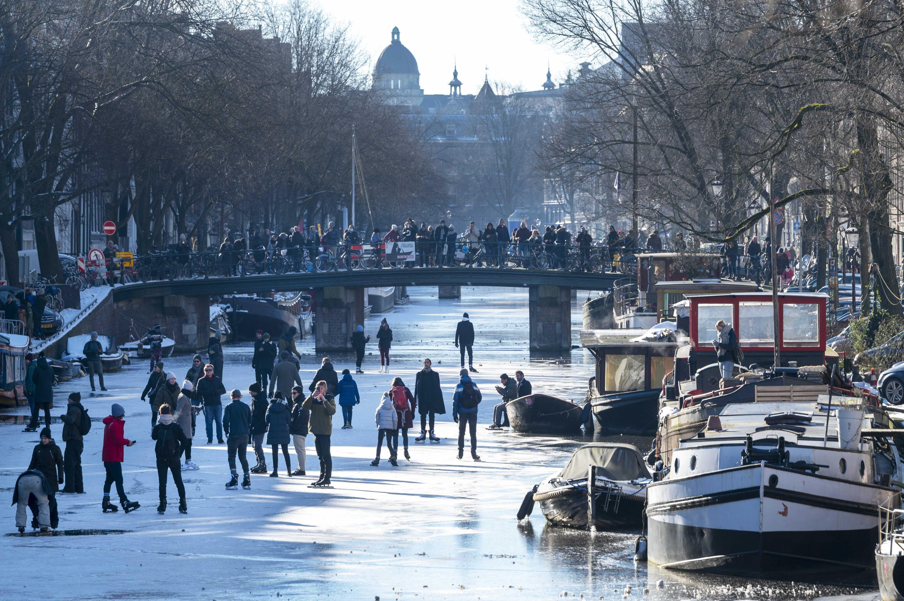 Ondata di gelo su Amsterdam: il canale ghiacciato diventa una pista di pattinaggio – Il video