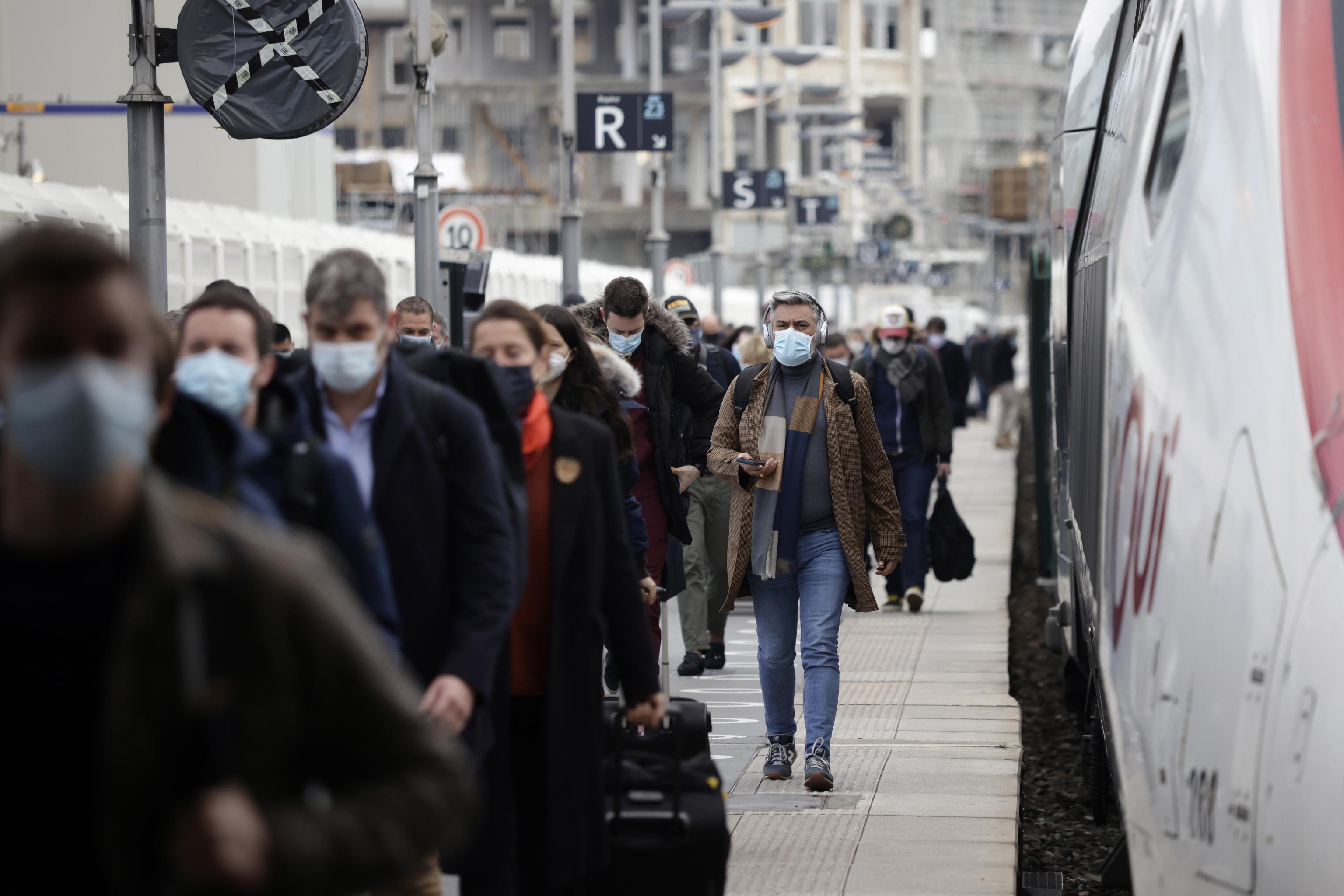 epa09084260 Commuters wearing protective face masks walk on the platform at Gare de Lyon train station in Paris, France, 19 March 2021. French Prime Minister Castex announced on 18 March additional lockdown restrictions in 16 areas of France, including Paris and the surrounding Ile-de-France region in the greater Paris region, as the country enters a third wave of the COVID-19 pandemic. The new lockdown restrictions , which go into effect at midnight on Friday 19 March, include the closure of 'non-essential' businesses (although schools remain open), a form is required to be outdoors within a 10 kilometer radius of one's home, and a curfew from 7pm to 6am remains in place. In the hours counting down to the application of the new restrictions, Parisians queued outside clothing retail shops and home furniture stores, anticipating their closure for a minimum of 4 weeks.  EPA/YOAN VALAT