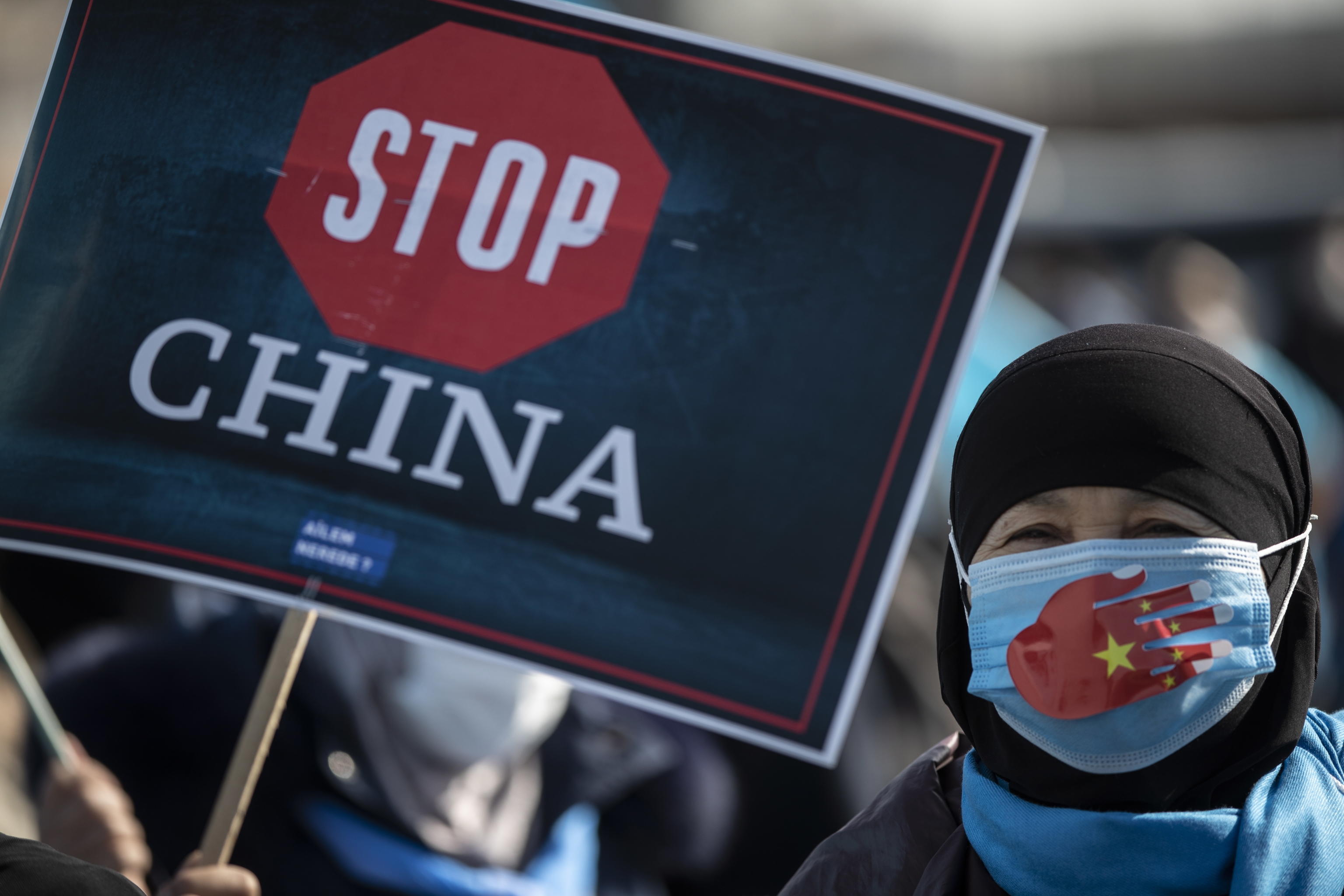 epa09038157 Uyghur protestors who have not heard from their families living in East Turkestan hold placards and Uyghur flag during a protest against China, in Istanbul, Turkey, 26 February 2021. The protest aims to highlight the critical situation of alleged human rights abuses of the Uyghur people and many other minority groups across the Xinjiang (East Turkestan) area in China.  EPA/TOLGA BOZOGLU
