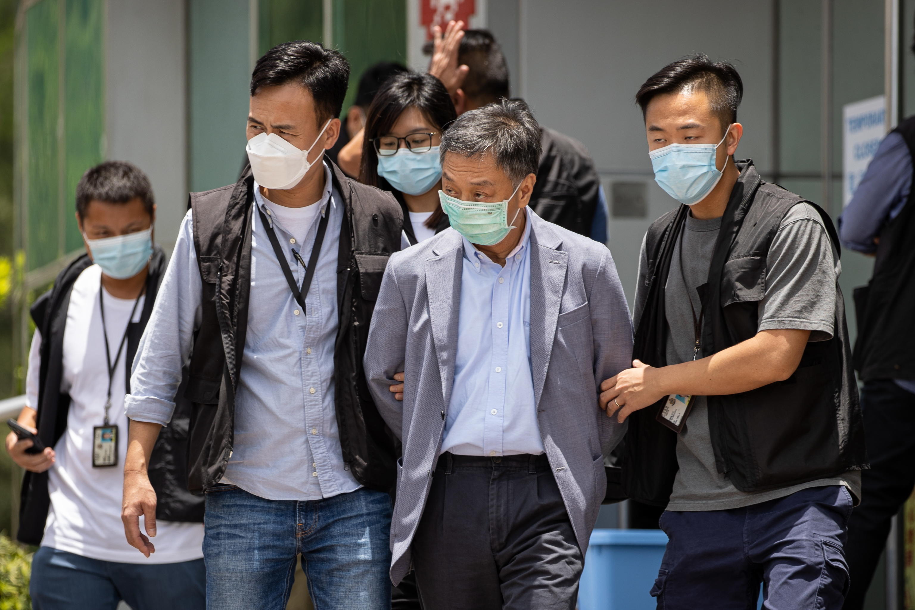 epa09278580 Apple Daily COO Royston Chow Tat Kuen (C) is escorted by police officers as he leaves the office of Next Media, publisher of Apple Daily, in Hong Kong, China, 17 June 2021. Hong Kong's national security police arrested five directors of the Apple Daily newspaper on suspicion of conspiracy to collude with foreign forces under the China-imposed legislation.  EPA/JEROME FAVRE