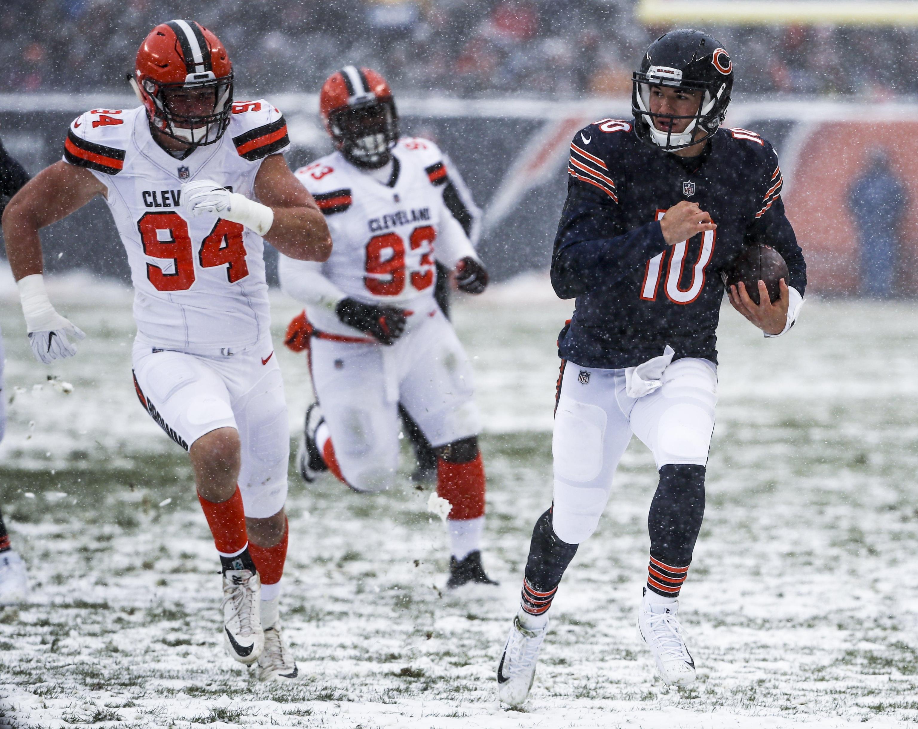 epa06404856 Chicago Bears quarterback Mitchell Trubisky (R) scrambles in the snow for a 12 yard gain as Cleveland Browns defensive end Carl Nassib (L) and Cleveland Browns defensive tackle Trevon Coley (C) pursue in the first half of their NFL game at Soldier Field in Chicago, Illinois, USA, 24 December 2017.  EPA/TANNEN MAURY