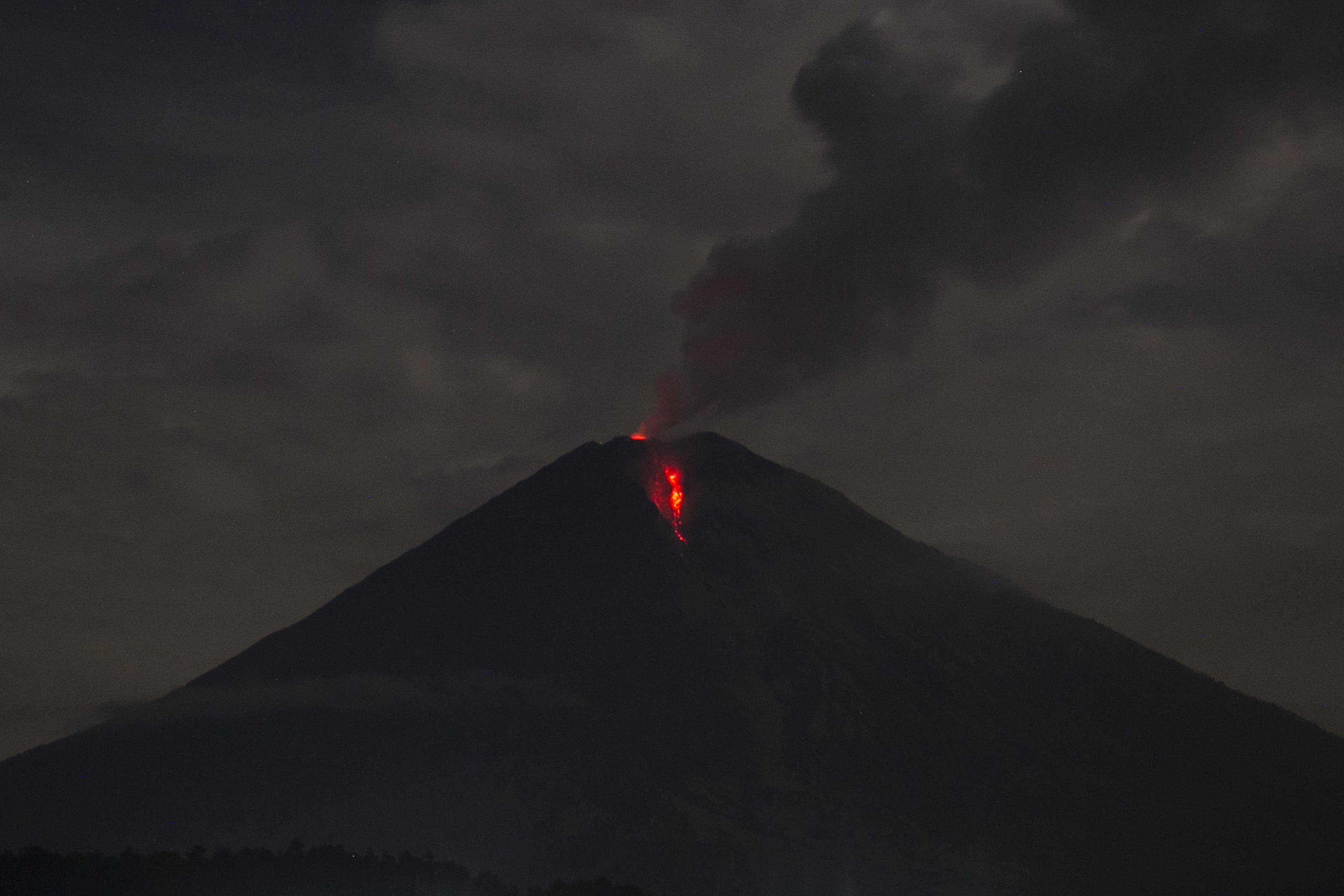 epa08858297 Lava streams down from Mount Semeru as seen from Lumajang, East Java, Indonesia, 02 December 2020. Semeru volcano erupted on 01 December, spewing hot ash 3,000 metres down its slopes, causing panic among villagers. Authorities are on high alert as several volcanoes showed increase in volcanic activities.  EPA/FULLY HANDOKO