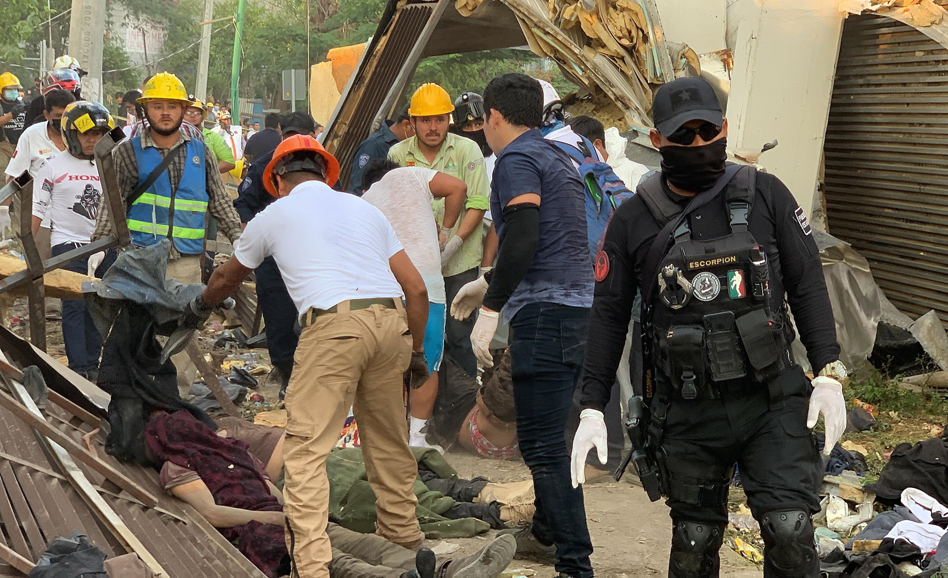 epa09633037 Rescuers and authorities work in the area of the accident of a truck where migrants were traveling, in the Chiapa de Corzo municipality, Chiapas state, Mexico, 09 December 2021. A total of 49 migrants lost their lives and another 58 were injured in an accident involving a truck on a highway in the southeastern Mexican state of Chiapas, according to official sources.  EPA/Carlos Lopez