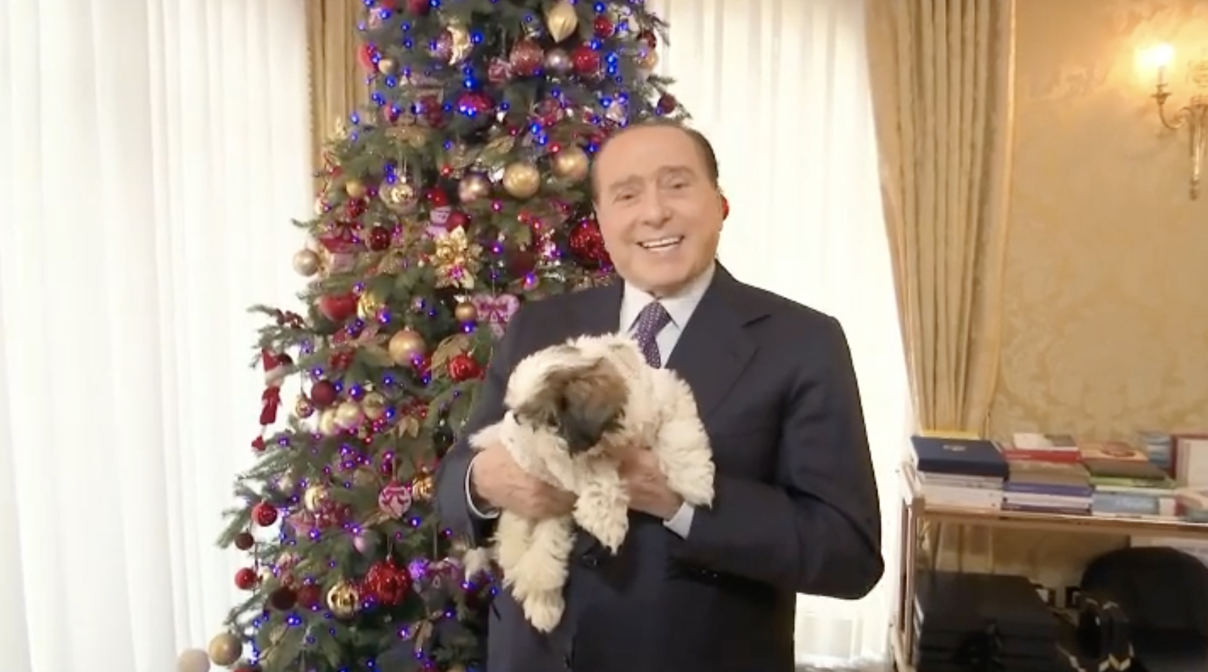 Gli auguri di Natale di Berlusconi con in braccio la new entry Gilda, ma senza la consueta spilla di FI – Il video