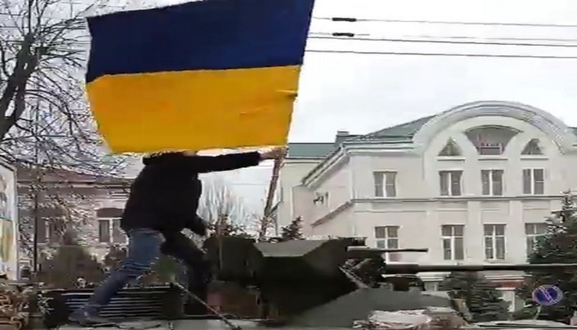 Sale sul carro armato russo per sventolare la bandiera ucraina. Il manifestante di Cherson simbolo della resistenza contro Mosca – Il video