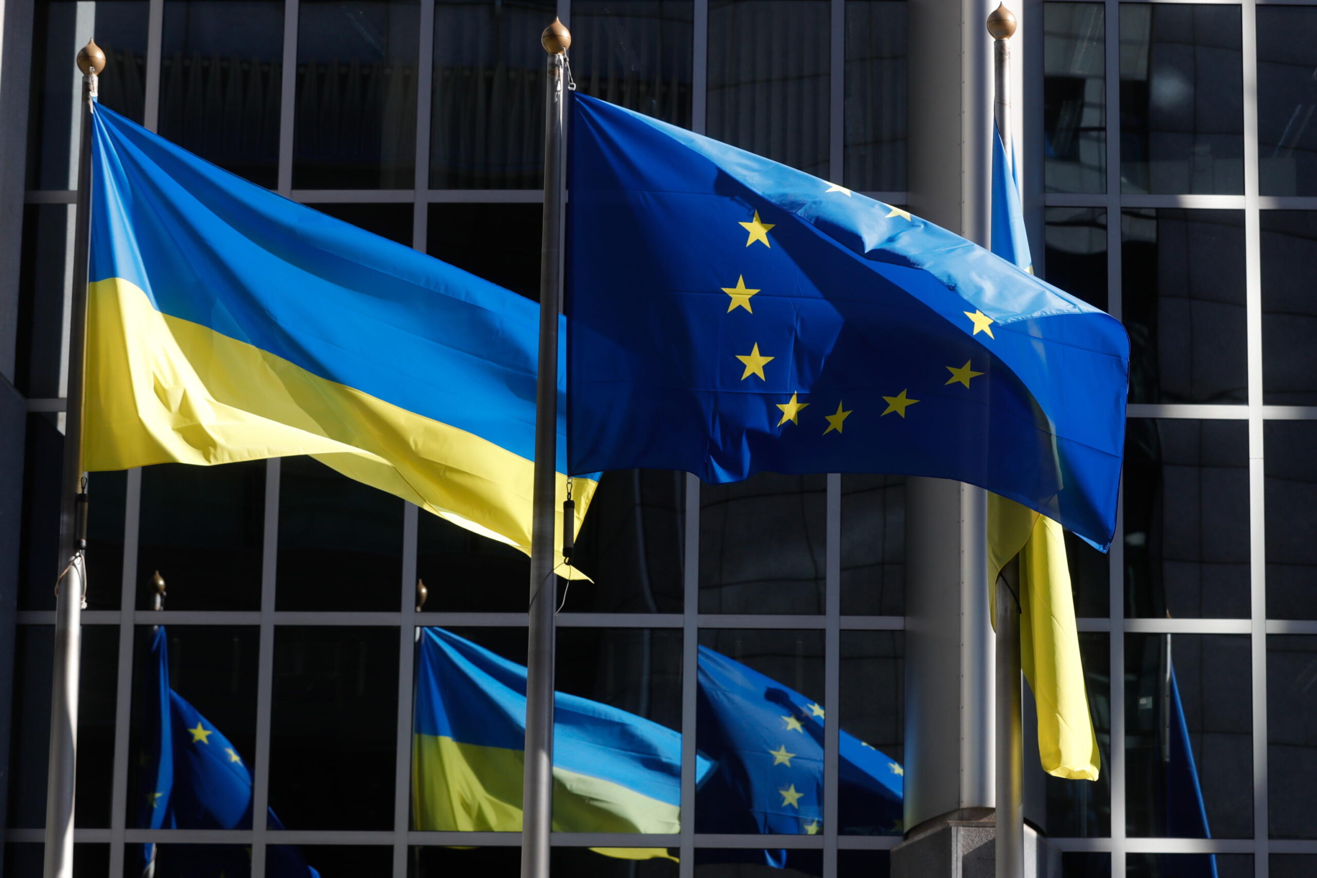 epa09791552 Ukrainian flags are hoisted along Flag of Europe to show solidarity with Ukraine over the Russian aggression, in front of the European Parliament in Brussels, Belgium, 28 February 2022. EU defence ministers are meeting via video conference on 28 February to discuss the latest situation on the ground in Ukraine, following Russia's military invasion.  EPA/STEPHANIE LECOCQ