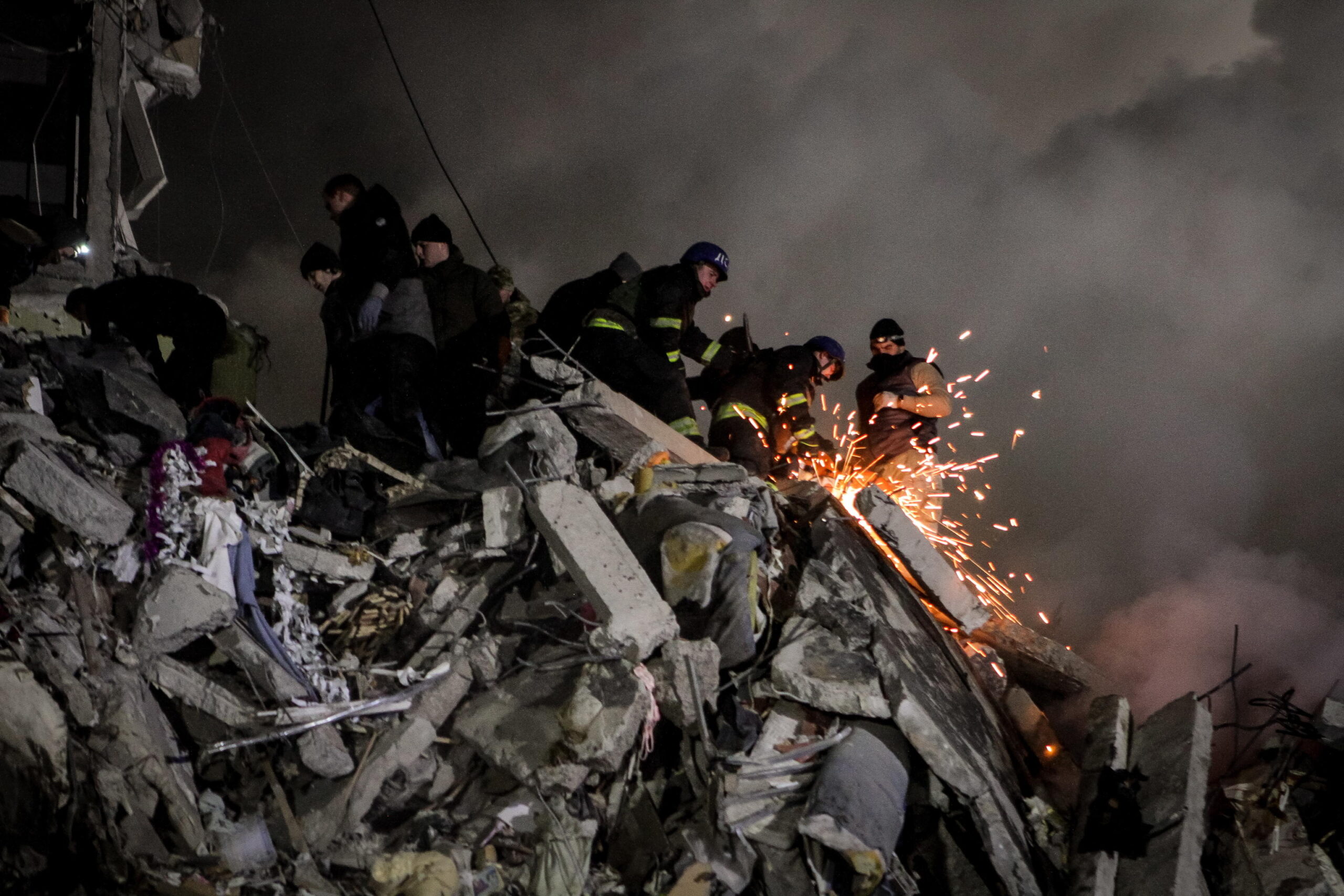 epa10405564 Rescue team work among the rubble of a damaged residential building hit by shelling in Dnipro, southeastern Ukraine, 14 January 2023, amid Russia's invasion. At least five people died and 38 others were injured, among them six children, after a rocket hit the nine-story building in Dnipro, the State Emergency Service (SES) of Ukraine reported on 14 January. Russian troops entered Ukraine on 24 February 2022 starting a conflict that has provoked destruction and a humanitarian crisis.  EPA/STR
