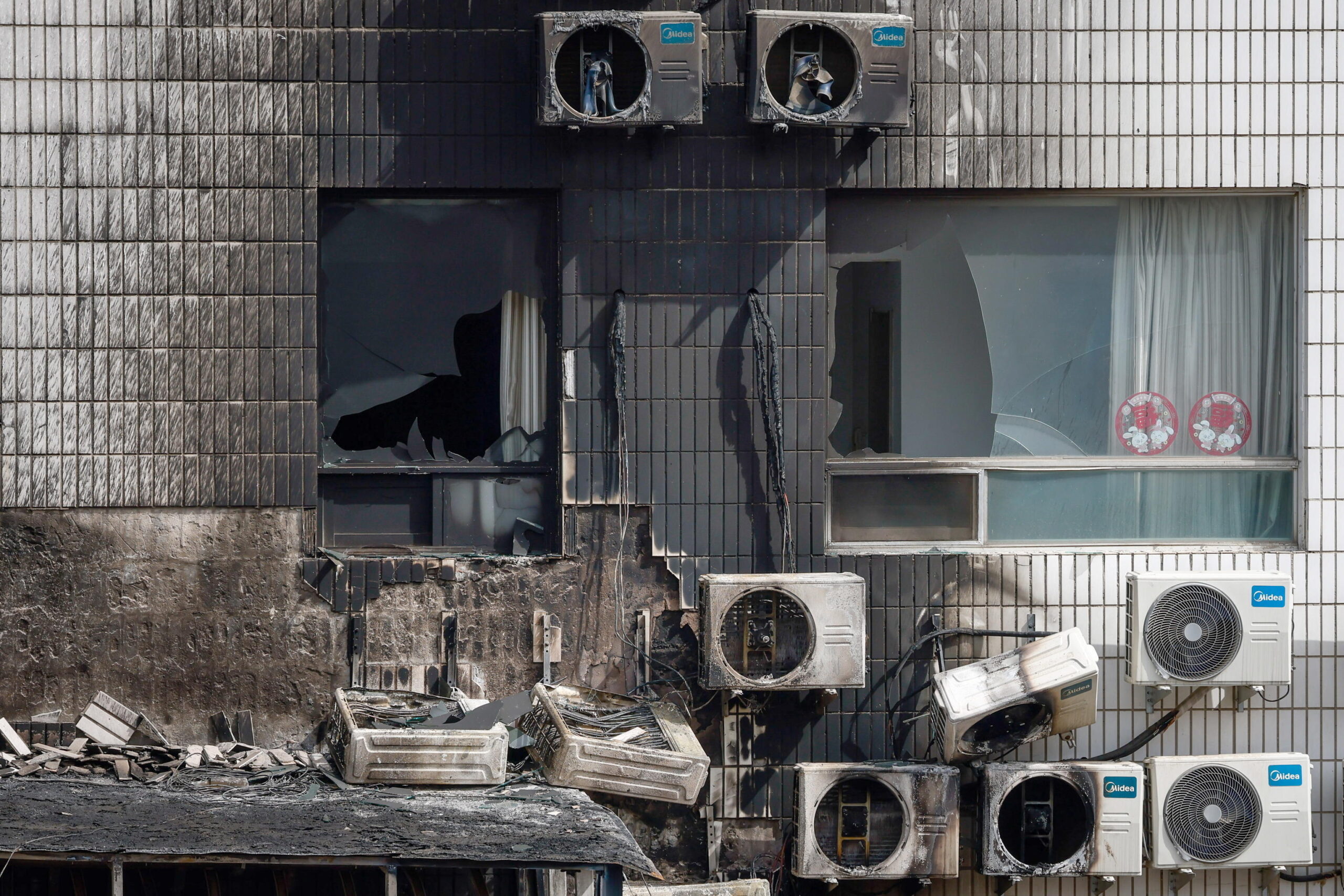 epa10579606 A view of broken windows and burned air conditioners following a fire at the Changfeng Hospital in Beijing, China, 19 April 2023. At least 21 people died following a fire at the Changfeng Hospital in the Fengtai district, Beijing state media reported. The cause of fire is currently under investigation.  EPA/MARK R. CRISTINO