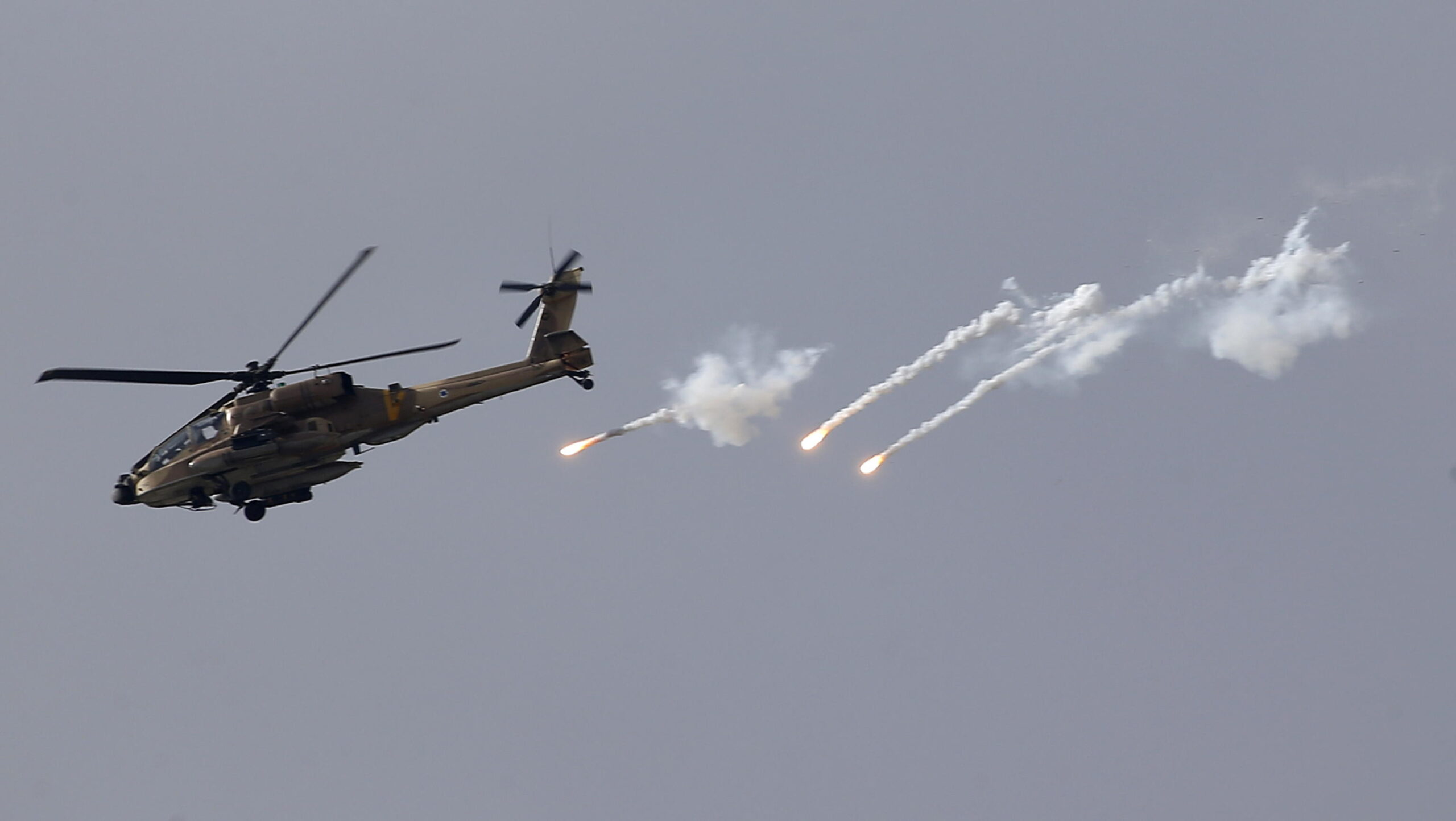 epa10699576 An Apache attack helicopter from Israel's military fires during an Israeli army raid in the West Bank city of Jenin, 19 June 2023. Israeli forces announced in a statement on 19 June, that they conducted a raid to 'apprehend two wanted suspects' in the city of Jenin. In a rare move, they used helicopters to open fire at what they described as armed gunmen. Israeli forces accused Palestinian gunmen of hurling at them 'large numbers of explosive devices', prompting them to respond with live fire. At least three people died, including a minor, and 31 others were injured during clashes, Palestinian Ministry of Health said.  EPA/ALAA BADARNEH
