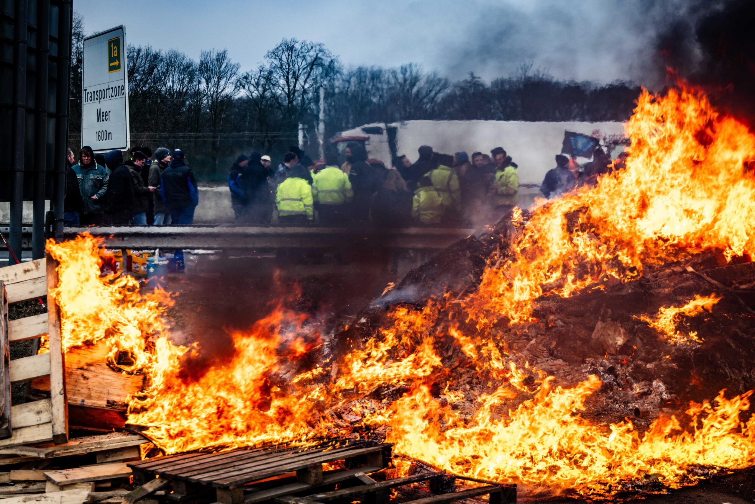 epa11119762 Dutch and Belgian farmers burn tires and wood as they block the border crossing at Hazeldonk, between the Netherlands and Belgium, 02 February 2024. The farmers demonstrate against agricultural rules that they believe are too strict and unfair competition within European borders.  EPA/JEFFREY GROENEWEG