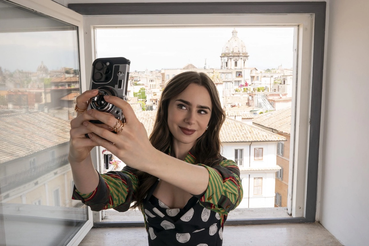 https://static.open.online/wp-content/uploads/2024/10/emily-in-paris-rome-selfie-scaled-copia.jpg