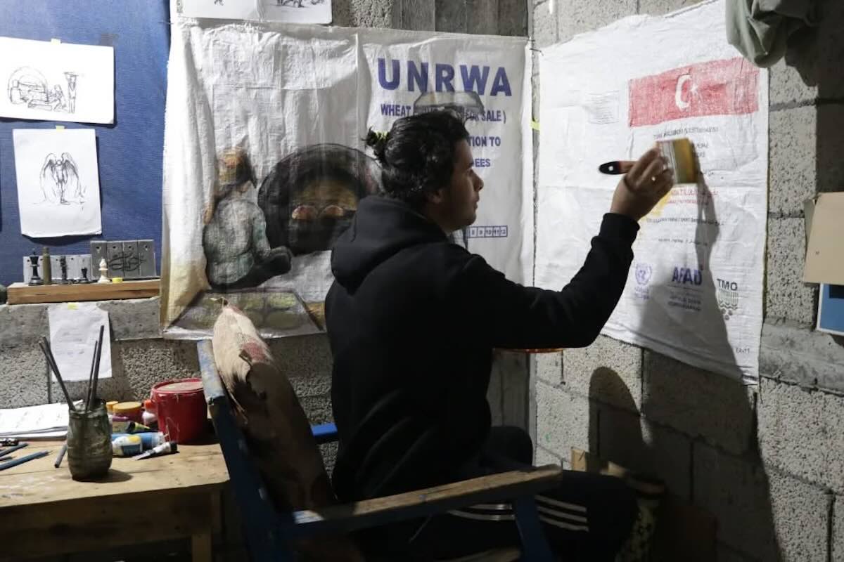 Gaza, l’artista che dipinge l’assenza di aiuti umanitari: «Così le scatole vuote diventano tele: l’arte è la mia unica libertà» – L’intervista Gaza, l’artista che dipinge l’assenza di aiuti umanitari: «Così le scatole vuote diventano tele: l’arte è la mia unica libertà» – L’intervista