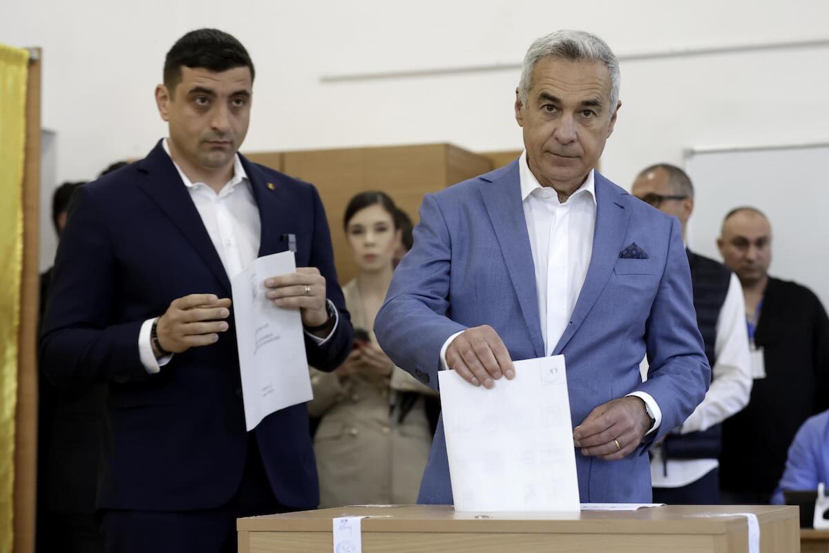 Elezioni in Romania, affluenza al 25%. Il candidato dell’ultradestra Simion al seggio con Georgescu: «Siamo qui per la democrazia»