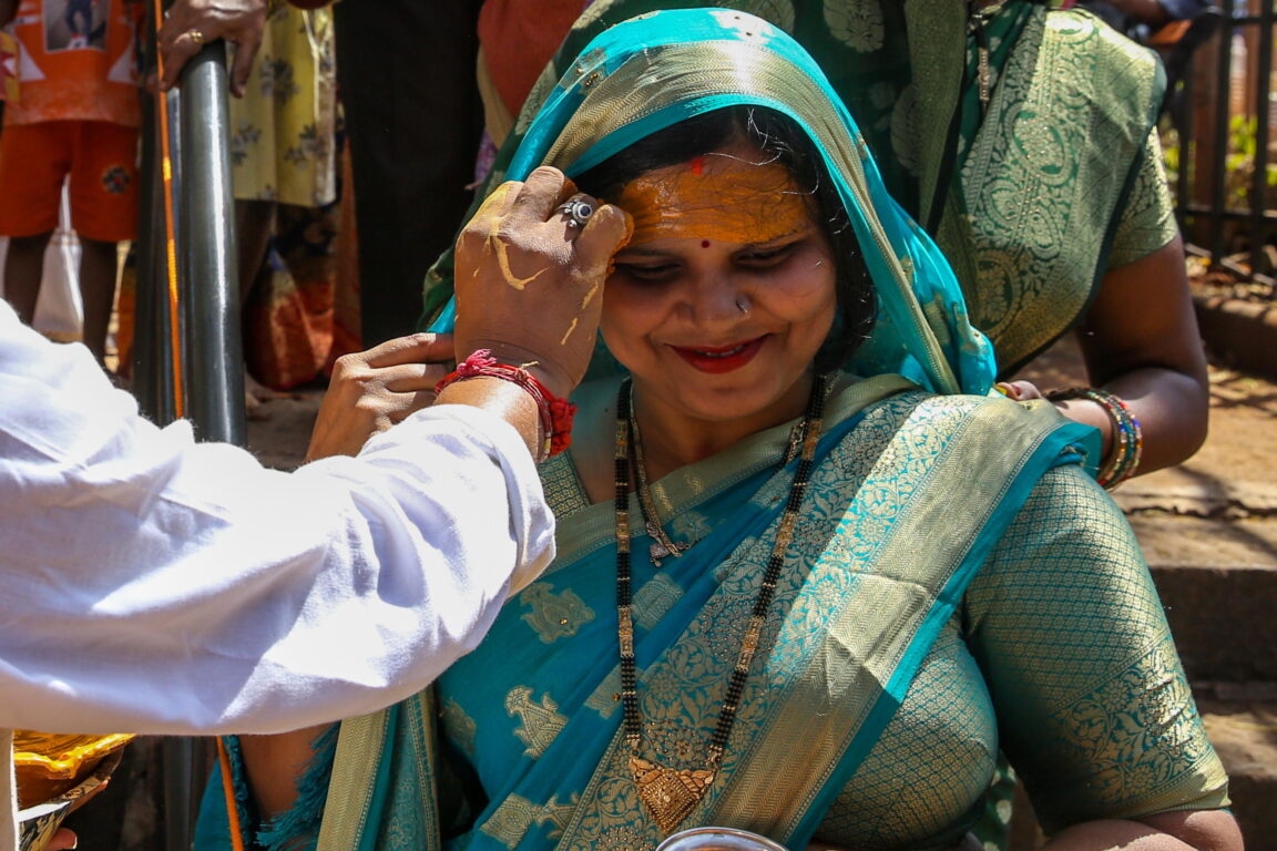 Donne che che riceve un tilak da un religioso indù - induismo