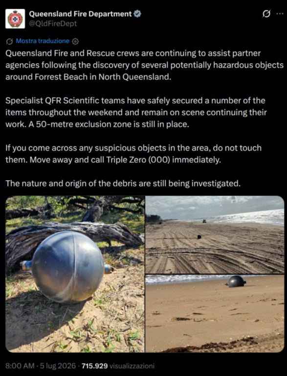 Vigili del fuoco in tuta anti-contaminazione esaminano una delle sfere metalliche rinvenute sulla spiaggia di Forrest Beach