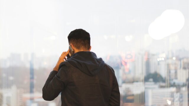 Uomo di spalle parla al telefono
