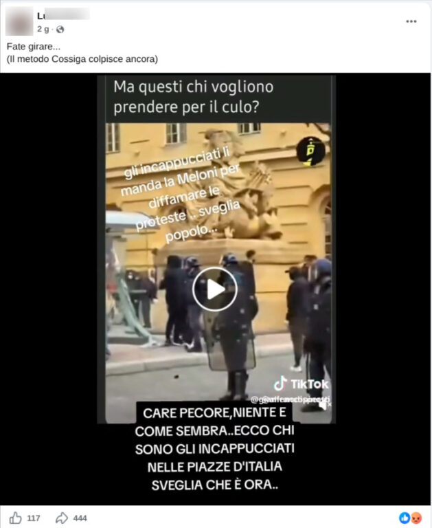 Schermata del video condiviso su Facebook con le scritte contro il governo, in cui persone incappucciate camminano verso un cordone di agenti antisommossa.